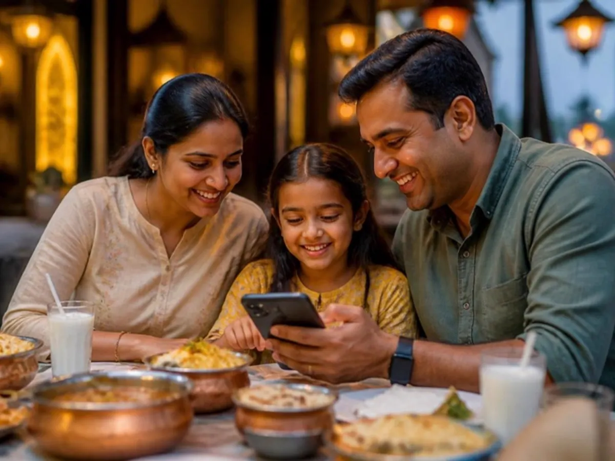 Family at a restaurant table looking at a phone